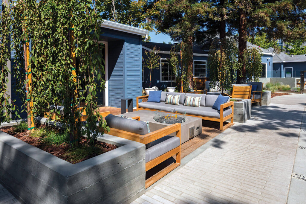 Outdoor chairs and sofa around a fire pit outside a leasing office