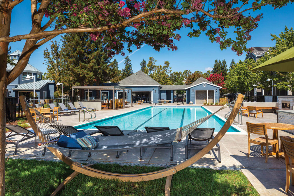 Hammock next to swimming pool with lounge chairs around it