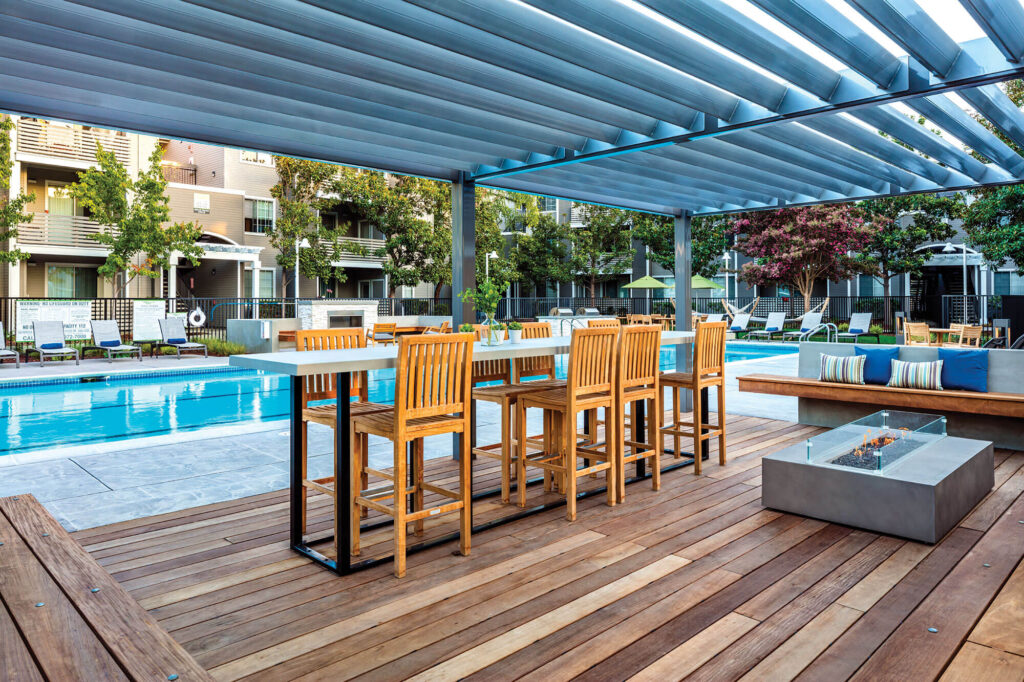 Shaded bar height seating area with fire pit and benches surrounding it